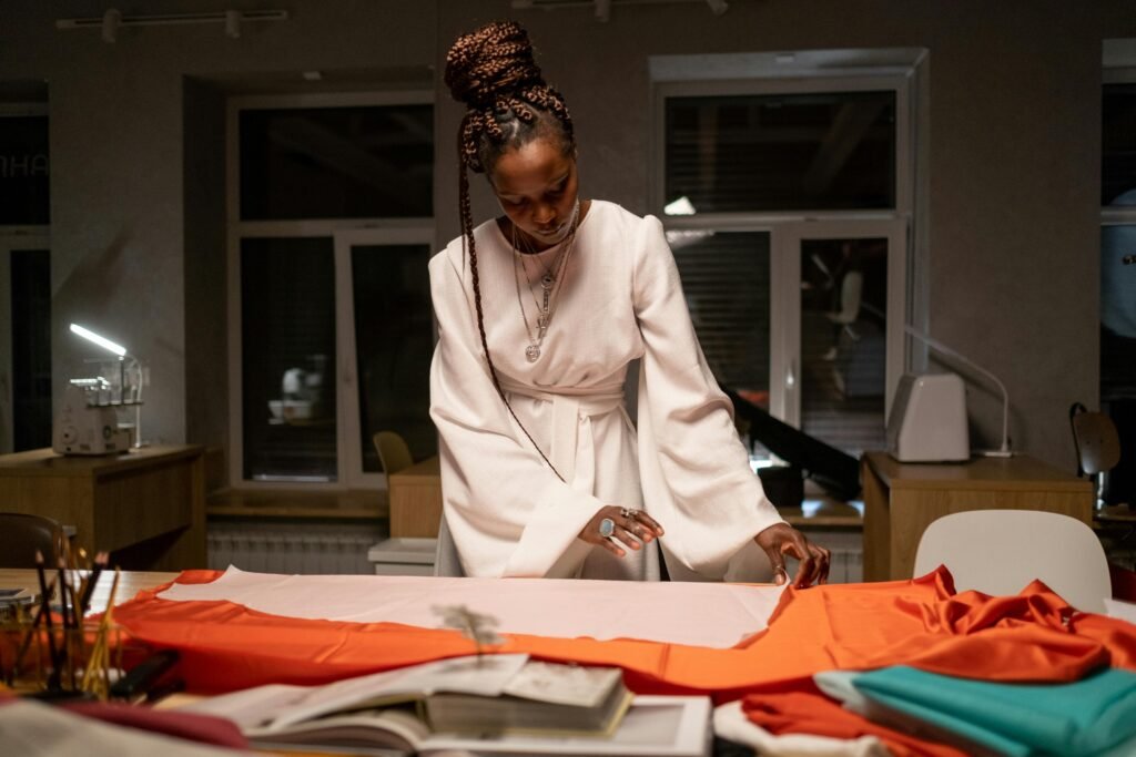 Female designer creating a dress in stylish workspace. Creative fashion professional at work.
